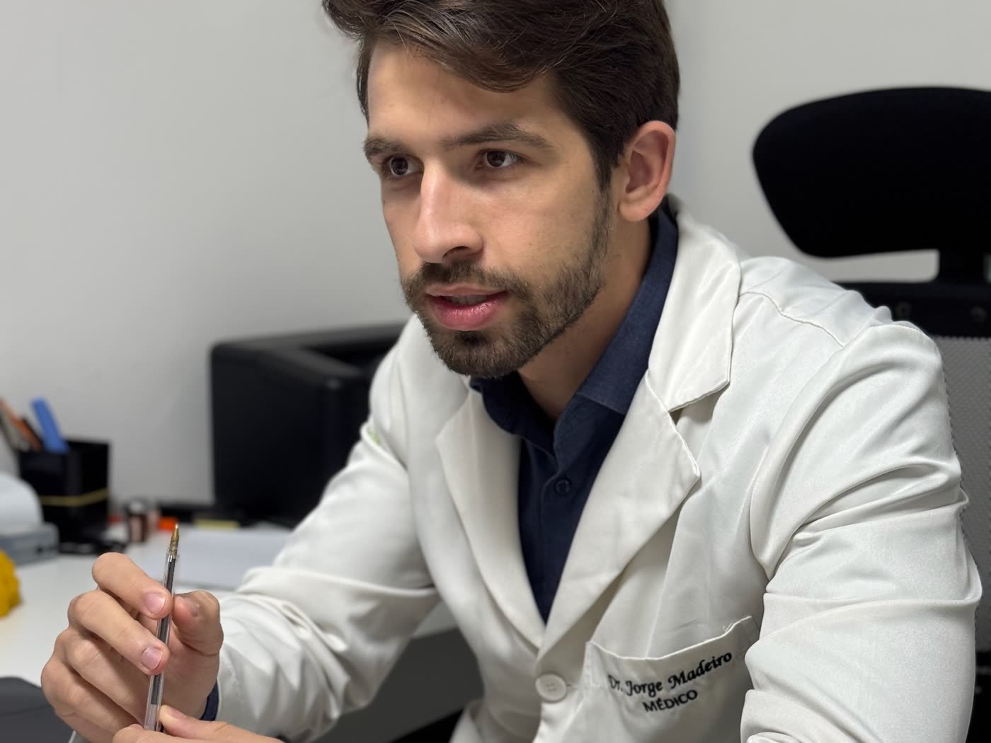 Dr. Jorge Madeiro no consultório, explicando o resultado da ferritina baixa no exame de sangue